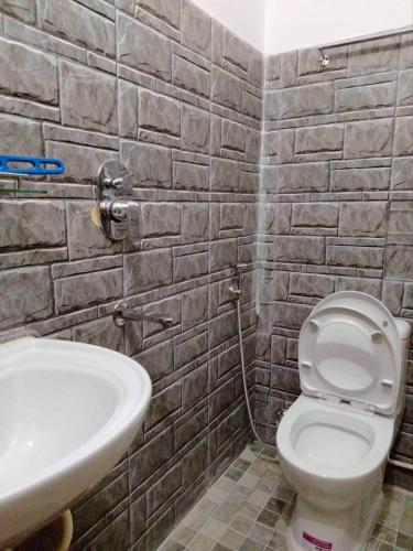 La salle de bains est pourvue de toilettes blanches et d'un lavabo. dans l'établissement Hotel Bandipur Bisauni, à Bandipur