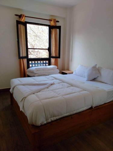 邦帝培的住宿－Hotel Bandipur Bisauni，卧室内的一张大床,设有窗户