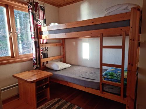 a room with two bunk beds and a desk at Sandy Beach Cottage in Uddevalla