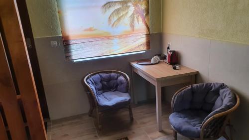 a room with two chairs and a table and a picture at Tawerna Rataje Pokoje Gościnne in Chodzież
