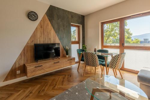 a living room with a television and a table and chairs at RentPlanet - Green Park Resort in Szklarska Poręba