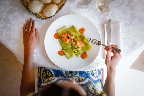 a person sitting at a table with a plate of food at Best Western Cavalieri Della Corona in Cardano al Campo
