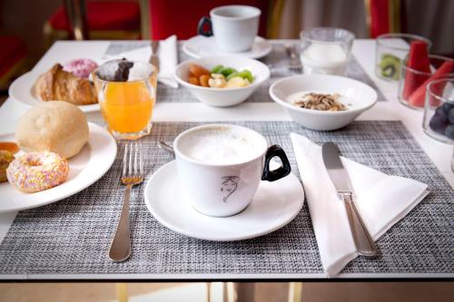 una mesa con una taza de café y platos de comida en Best Western Cavalieri Della Corona, en Cardano al Campo