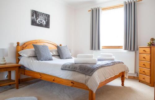 um quarto com uma cama de madeira e almofadas azuis em Tulm Bay em Kilmaluag