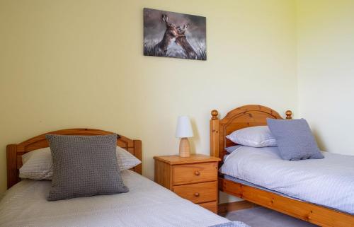 a bedroom with two beds and a picture of a wolf at Tulm Bay in Kilmaluag