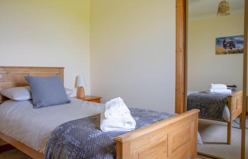 a bedroom with a bed and a mirror at Tulm Bay in Kilmaluag