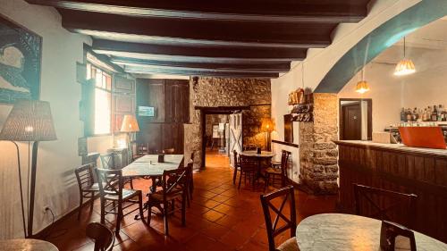a dining room with tables and chairs and a bar at La Fonda de Xiva in Chiva de Morella