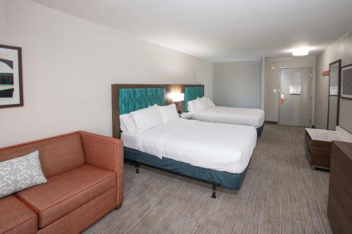 a hotel room with two beds and a couch at Hampton Inn Dry Ridge in Dry Ridge