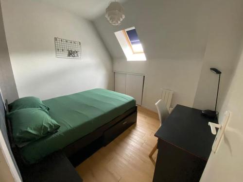 a small bedroom with a green bed and a desk at Le Lagon bleue T avec extérieur in Amiens