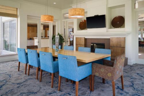 a dining room with a wooden table and blue chairs at Hilton Garden Inn Houston/Bush Intercontinental Airport in Houston