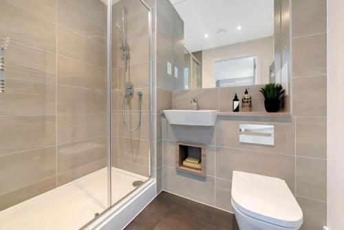a bathroom with a shower and a toilet and a sink at Chic 2 Bed Riverside Retreat in Rochester