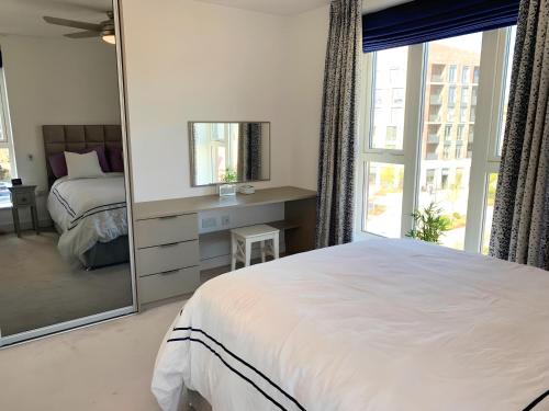 una camera da letto con un grande letto bianco e uno specchio di Chic 2 Bed Riverside Retreat a Rochester