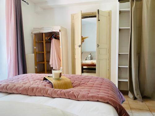 a bedroom with a bed with a pink blanket at Appart Karibu in Callian