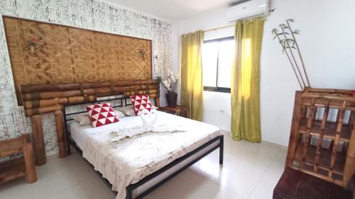 a bedroom with a bed with red and white pillows at Verano GuestHouse in Tagbilaran City