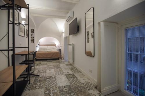 un couloir avec un lit et une chambre avec une fenêtre dans l'établissement Cartoline di Napoli, à Naples