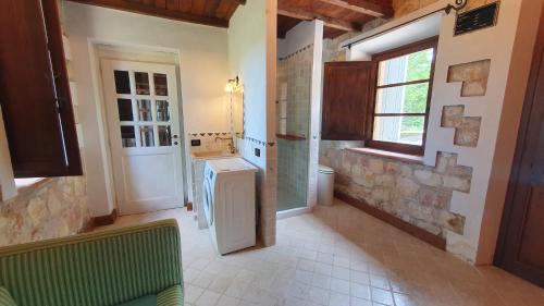 une salle de bains avec lave-linge et sèche-linge dans une chambre dans l'établissement La Bandita Cottage, à San Venanzo