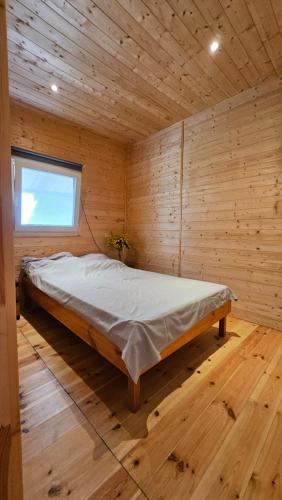 1 dormitorio con 1 cama en una habitación de madera en J&L GRADZKIE en Grądzkie