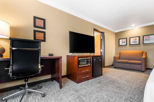 a hotel room with a television and a desk with a chair at Comfort Inn & Suites Redwood Country in Fortuna