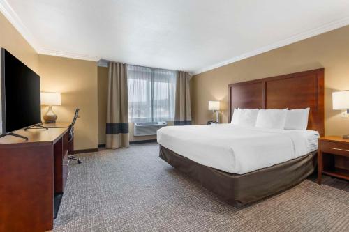 a hotel room with a bed and a flat screen tv at Comfort Inn & Suites Redwood Country in Fortuna