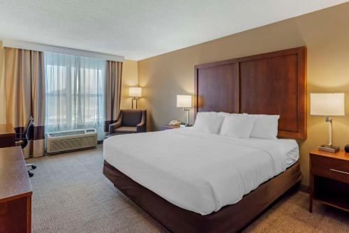 um quarto de hotel com uma cama grande e uma cadeira em Comfort Inn & Suites em Dover