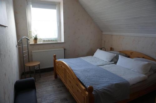 a bedroom with a bed and a window and a chair at Ferienwohnungen Bauernhof Beckmann in Winsen Aller