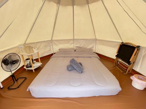 Un colchón cama en una tienda de campaña con ventilador. en Merry Camp Khaokho, en Khao Kho