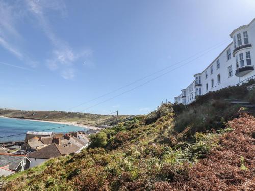 a building on top of a hill next to a beach at Starfish in Penzance