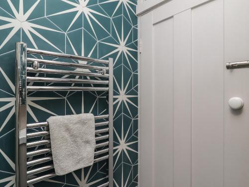 a bathroom with a blue and white geometric wallpaper at Starfish in Penzance