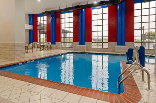 una piscina con agua azul en un edificio con ventanas en Best Western Plus Greenwood Indy South Inn, en Greenwood