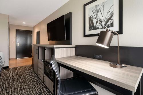 a desk in a room with a lamp and a television at Best Western Plus Greenwood Indy South Inn in Greenwood