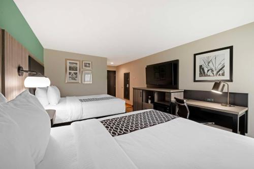 a hotel room with two beds and a desk at Best Western Plus Greenwood Indy South Inn in Greenwood