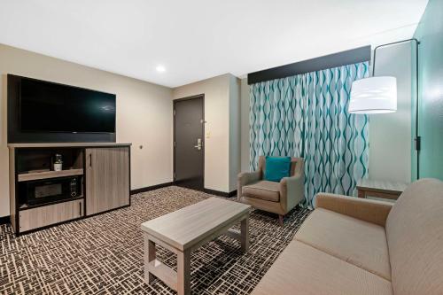 a living room with a couch and a tv at Best Western Plus Greenwood Indy South Inn in Greenwood