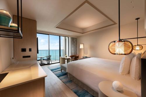 宮古島にあるヒルトン沖縄宮古島リゾートのベッド付きのホテルルームで、海の景色を望めます。