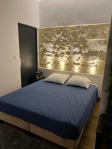 - une chambre dotée d'un lit bleu et d'une peinture murale dans l'établissement La Suite Triangle d'or, à Bordeaux