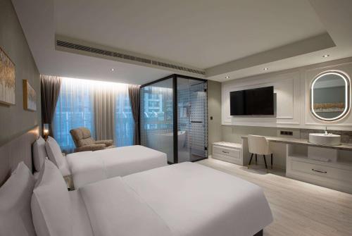 um quarto de hotel com duas camas e uma televisão em TRYP by Wyndham New Taipei Linkou 新北林口爵怡溫德姆酒店機場捷運MRTA9林口站 em Linkou