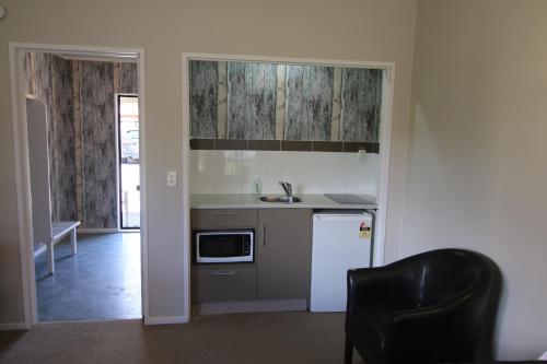 a kitchen with a sink and a refrigerator at Apex on Fenton in Rotorua