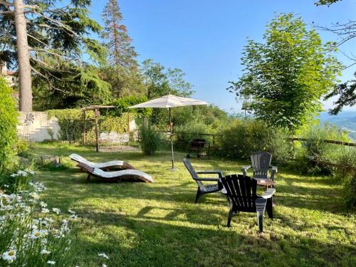 two chairs and an umbrella in a yard at BEE HOUSE Ponzone in Ponzone