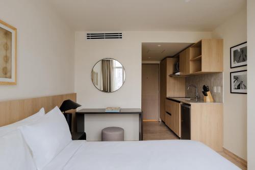 1 dormitorio con 1 cama blanca y cocina en Sonder Las Alas, en Ciudad de México