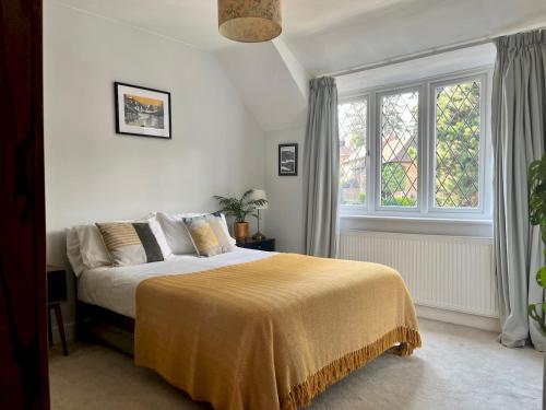 1 dormitorio con cama y ventana grande en Pass the Keys Cosy 3 Bed Cottage in Chorleywood, en Chorleywood