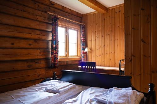 um quarto com uma cama numa parede de madeira em Skanckegårdene AS em Røros