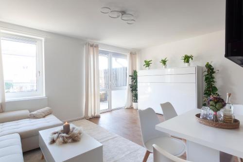 una sala de estar blanca con mesa blanca y sillas en Fabulous 2 Room City Apartment - 60 qm - Contactless Check-in, en Hannover