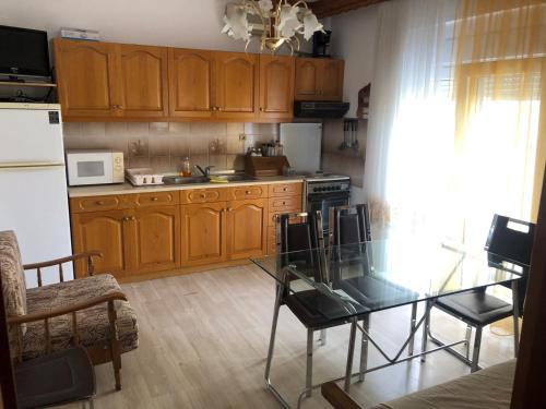a kitchen with wooden cabinets and a glass table at STOUDIO VOUL in Alexandroupoli