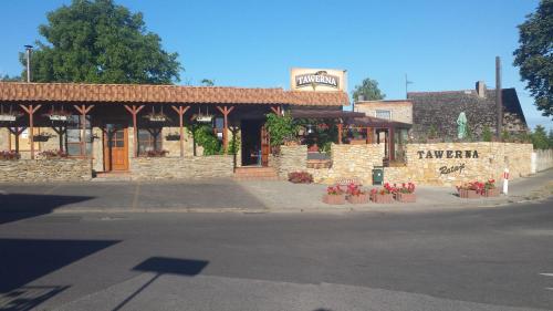 a restaurant on the side of a street with a building at Tawerna Rataje Pokoje Gościnne in Chodzież