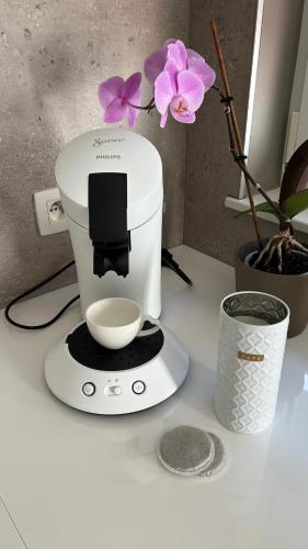 a white mixer sitting on a counter next to a flower at Casa Polizzi - Maison entière in Fontaine-lʼÉvêque