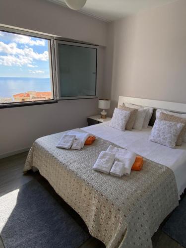 een slaapkamer met een groot bed met kussens en een raam bij Getaway to Blue Paradise at Madeira Island in Funchal