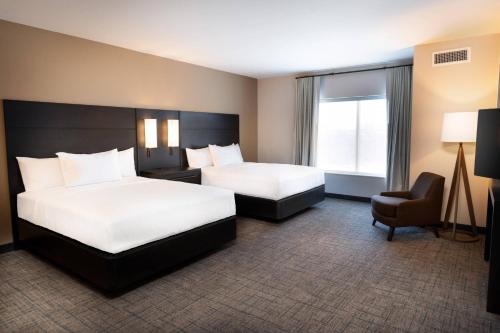 um quarto de hotel com duas camas e uma cadeira em Residence Inn by Marriott Louisville Old Henry em Louisville