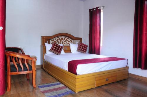 Schlafzimmer mit einem Bett mit roten Vorhängen und einem Stuhl in der Unterkunft Ramstays Valley View Kanthalloor in Kanthalloor