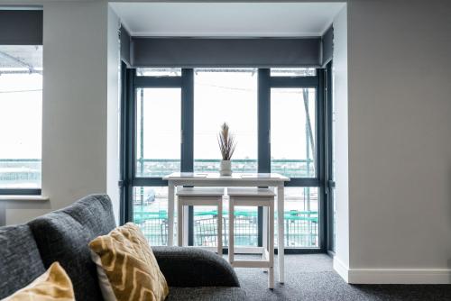 a living room with a table in front of a window at K Suites - Colne House in Lowestoft