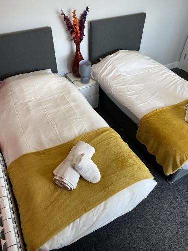 a pair of beds with towels sitting on them at K Suites - Colne House in Lowestoft