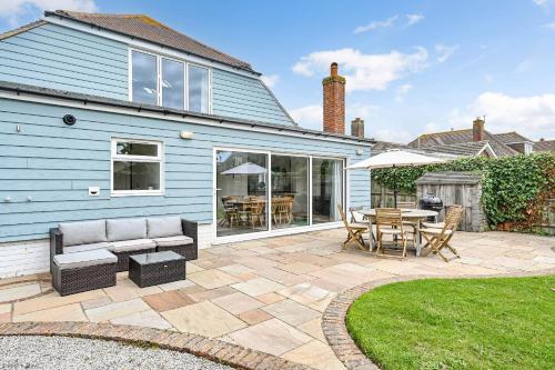 a patio with a couch and a table and chairs at Marine House by inspirestays-com in East Wittering